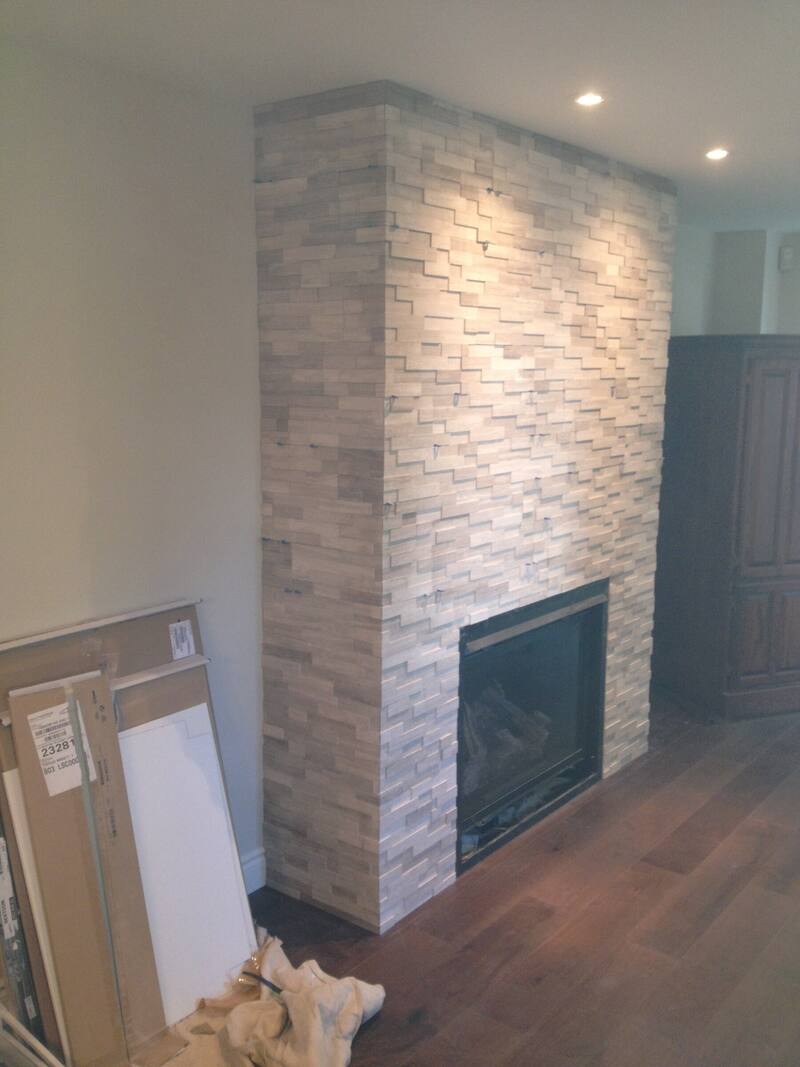 Floor-to-ceiling stacked tile fireplace surround in warm neutral tones