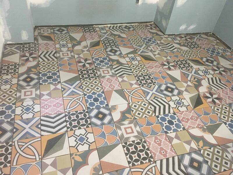 Colourful patchwork pattern floor tile laid across a bathroom